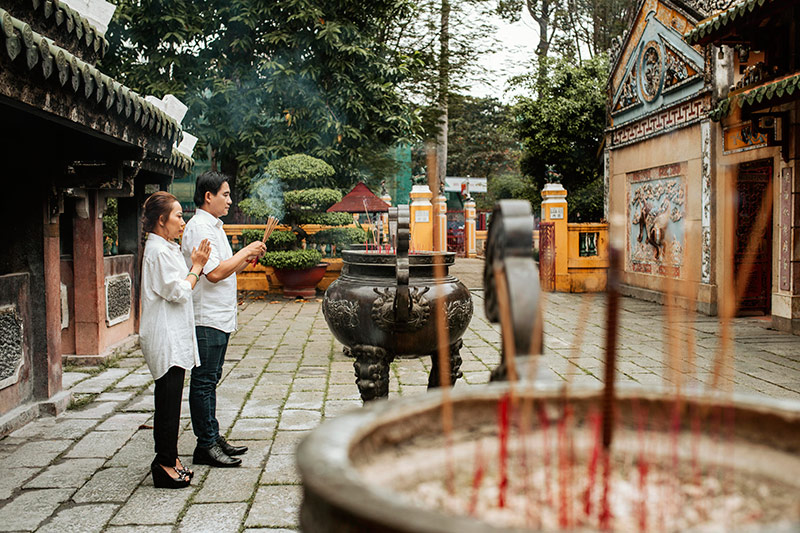 side-view-man-woman-praying-temple-with-burning-incense